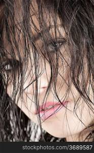 close-up in the face of nice brunette keeping her wet hair in front of her face