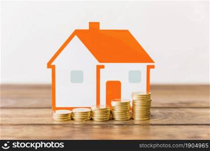 close up increasing stacked coins house model wooden desk. Beautiful photo. close up increasing stacked coins house model wooden desk