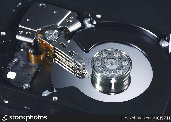 Close up internal of hard disk drive having a metal alloy disc platters and actuator arms inside with component