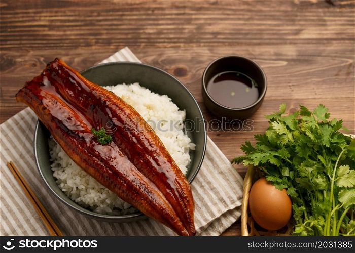 Close-up Japanese grilled eel served over rice or Unagi don set on plate. Japanese food on restaurant table