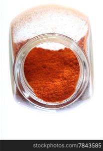 Close up jar with paprika spice isolated on white background