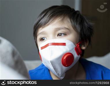 Close up kid face looking tired from chest coughing wearing face mask for protect pm2.5, Head short Loney Child boy with sad face stay at home for protection form coronavirus,flu outbreak and illness protection concept