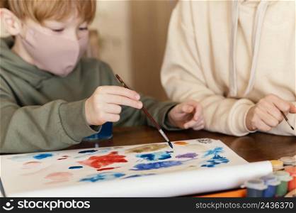 close up kid holding painting brush 2