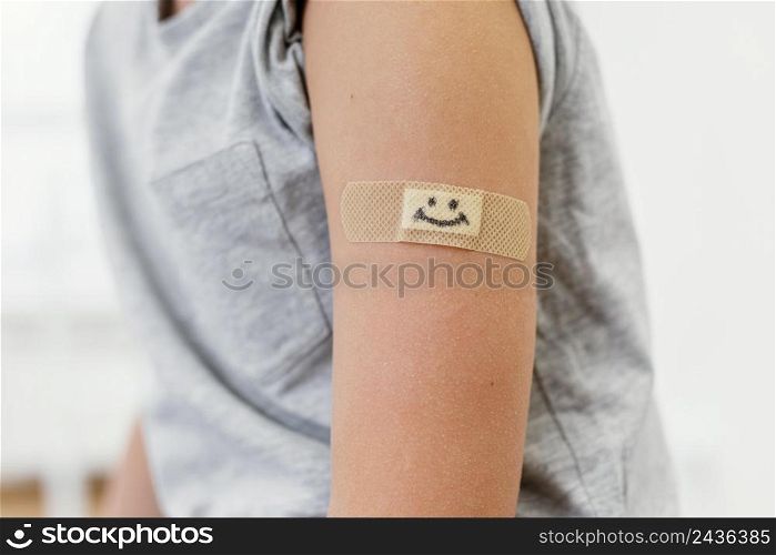 close up kid wearing smiley patch arm