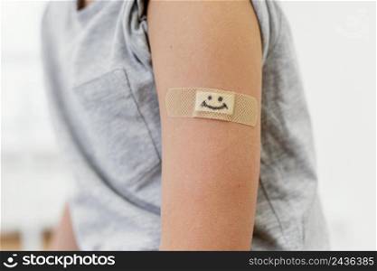 close up kid wearing smiley patch arm