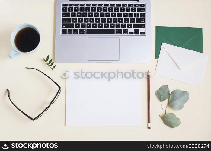 close up laptop with envelope paper pencil eyeglasses tea cup eyeglasses colored backdrop