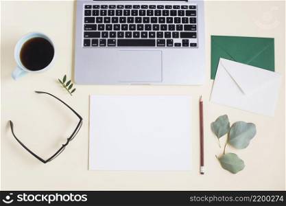 close up laptop with envelope paper pencil eyeglasses tea cup eyeglasses colored backdrop