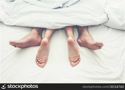 Close up legs of couple in bed.. Close up legs of couple in bed.