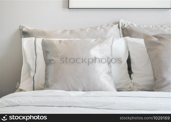 Close up light gray satin pillows on bed