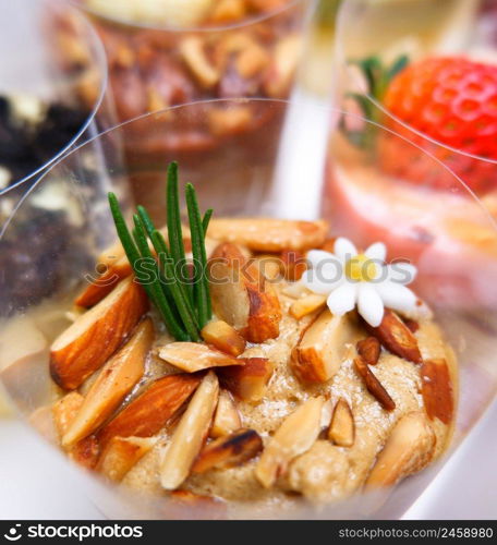 Close up macro of Coffee Cheesecake with fresh almond slices and rosemary leaf on top and different flavors of cheesecake