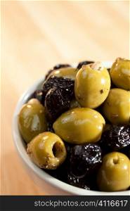 Close up macro photograph of a bowl of stuffed green and black italian olives