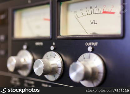 Close up macro photograph of analogue UV sound volume meter and control dials in a rcording studio or on a mixing desk