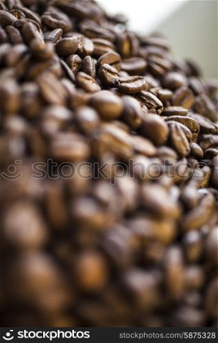 Close up macro shallow depth of field photograph of coffee beans in golden light