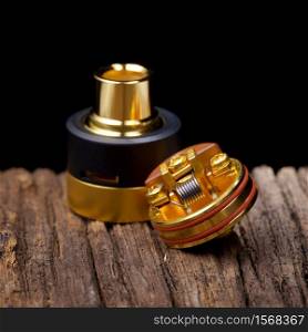 close up, macro shot of high end rebuildable dripping atomizer for flavour chaser on natural wood texture background, vaping device, selective focus