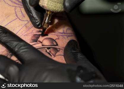 Close up macro view of tattooing process. Master makes contouring lines with his handmade professional liner machine. High quality photography. Close up macro view of tattooing process. Master makes contouring lines with his handmade professional liner machine.