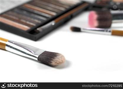 Close up makeup brushes with eye shadows palette and brushes background.