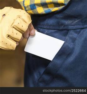 close up male carpenter removing white blank card from his pocket
