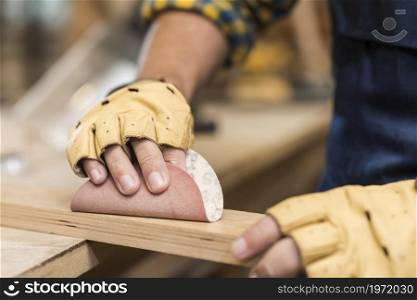 close up male carpenter rubbing down wood with sandpaper. High resolution photo. close up male carpenter rubbing down wood with sandpaper. High quality photo