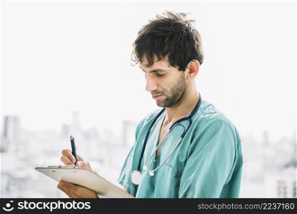 close up male doctor writing clipboard