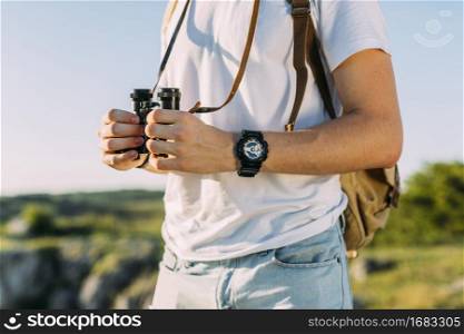 close up male hiker holding binocular his hand