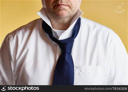 Close up, male wearing white shirt and blue tie, loose tie, yellow background