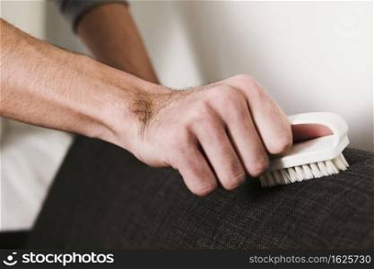 close up man brushing couch