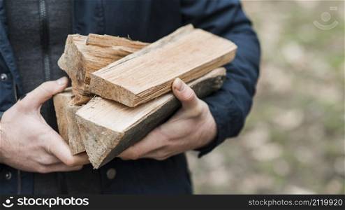 close up man carrying wood