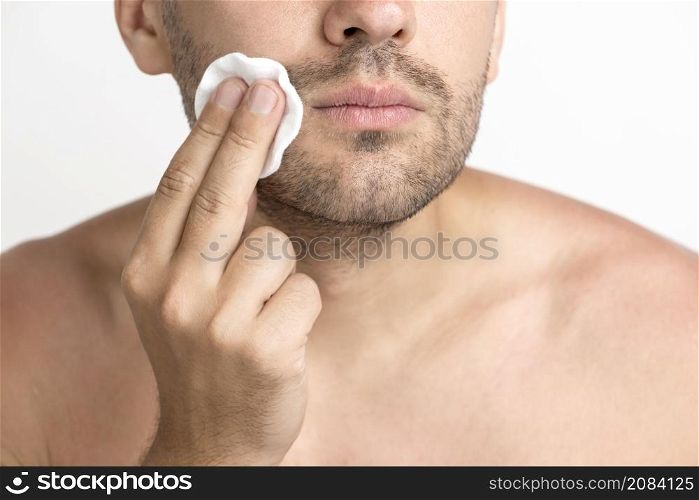 close up man cleaning face with cotton pad