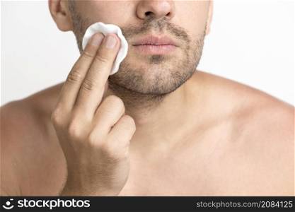 close up man cleaning face with cotton pad