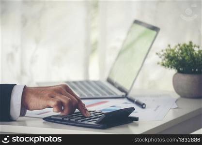 Close up Man hands calculating number, data, graph, chart audit planning accountancy on business report. Business man hands using calculator counting tax financial bill. Tax audit Finacial concept.
