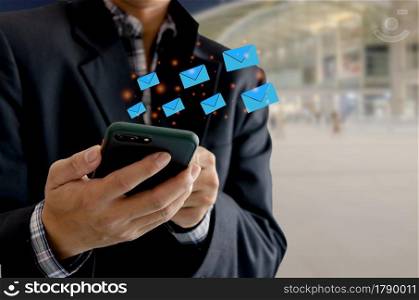 Close-up man holding a cell phone an icon email message. Marketing business sending information to customers or hacking online transactions. Business concept technology.
