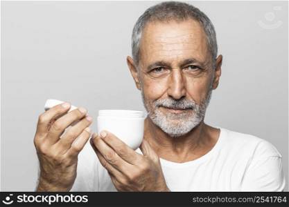 close up man holding cream container