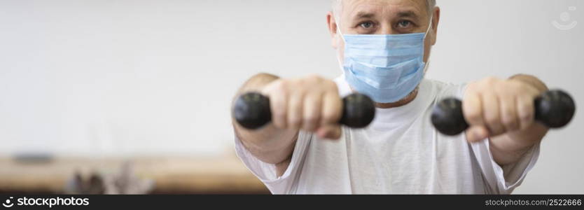 close up man holding dumbbells