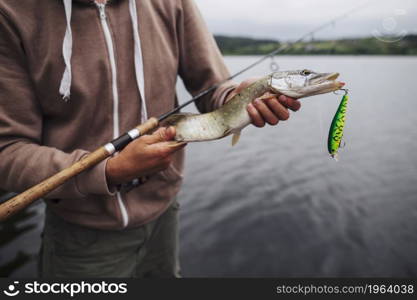 close up man holding freshly caught fish with lure. High resolution photo. close up man holding freshly caught fish with lure. High quality photo