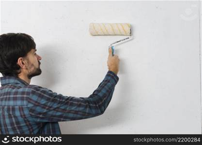 close up man painting wall with paint roller
