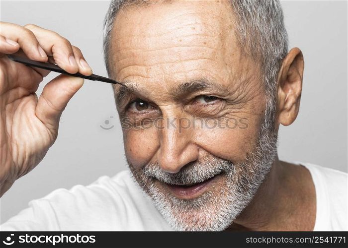 close up man plucking his eyebrow