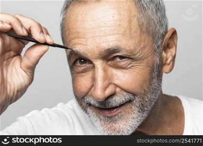close up man plucking his eyebrow