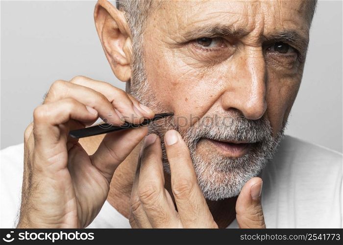 close up man plucking his face