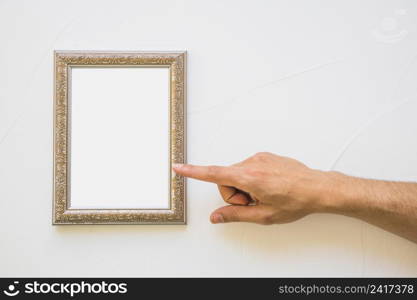 close up man pointing white golden picture frame wall