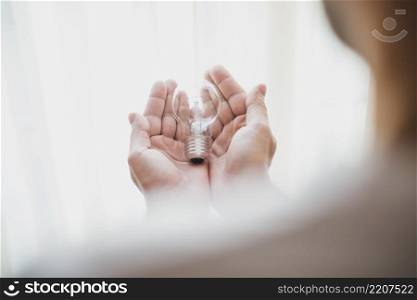 close up man s hand holding light bulb