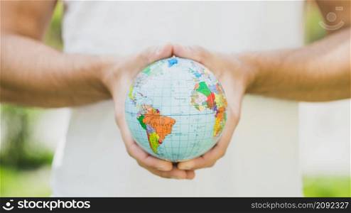close up man s hand holding small globe