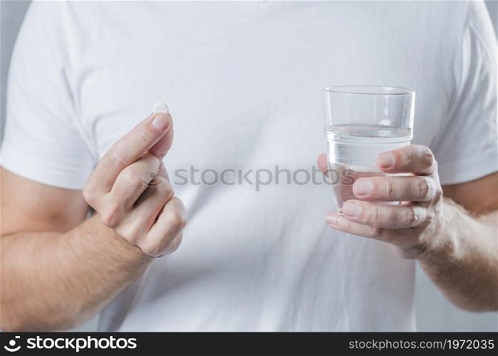 close up man s hand holding white pill glass water hand. High resolution photo. close up man s hand holding white pill glass water hand. High quality photo