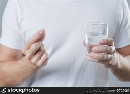 close up man s hand holding white pill glass water hand. High resolution photo. close up man s hand holding white pill glass water hand. High quality photo