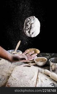 close up man s hand throwing bread dough air