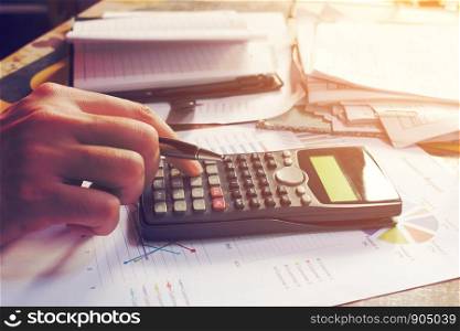 Close up man using calculator and doing finance in home office.