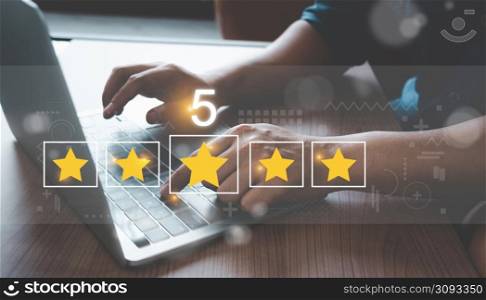 Close up man using Lap top for rating feedback from customer service with annual survey with five gold star icon. Business annual satisfaction survey concept. User reviews and feedback online.