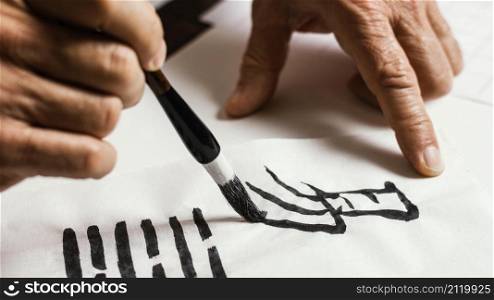 close up man writing chinese symbols white paper