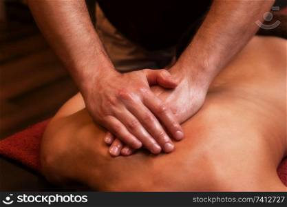 Close-up masseur hands doing back massage to woman in spa center.. back massage to woman
