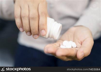 Close up mature woman taking out pills from bottle