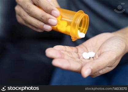 Close up mature woman taking out pills from bottle